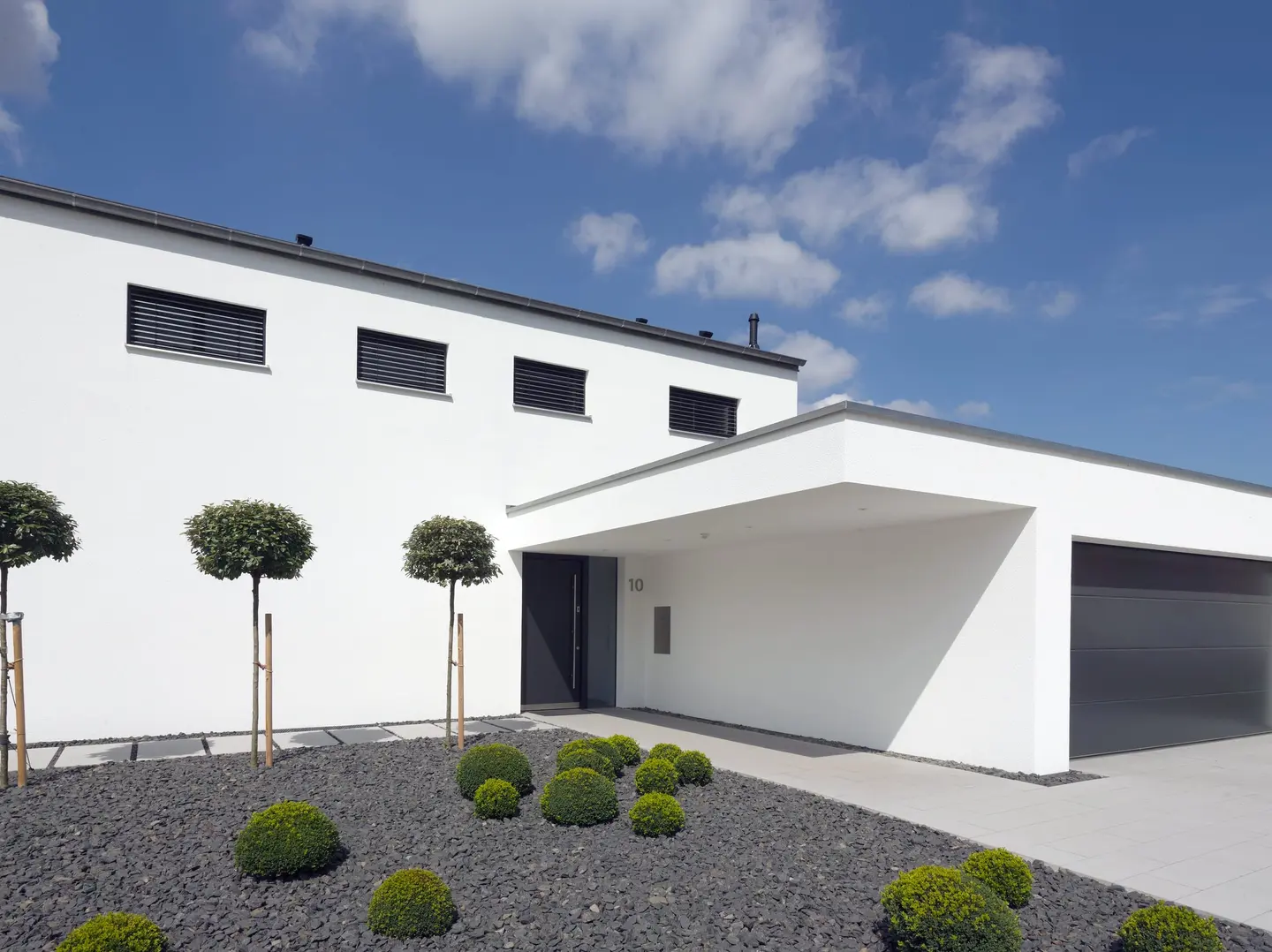 Flachdachhaus mit Carport, Fensterbändern und Vorgarten